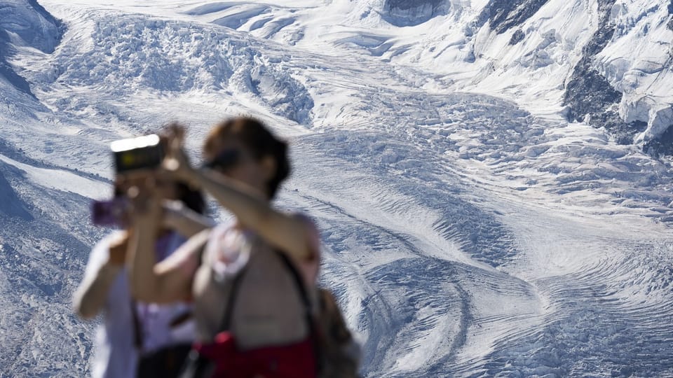 Touristen fotografieren sich vor dem auf dem Gornergrat, oberhalb von Zermatt.