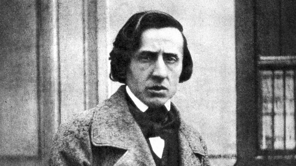 Porträt von Frédéric Chopins, in Mantel, vor einem Regal.