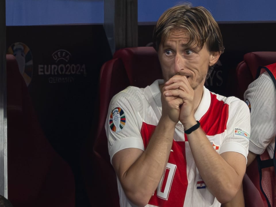Fussballspieler mit besorgtem Ausdruck auf der Auswechselbank bei der UEFA Euro 2024.