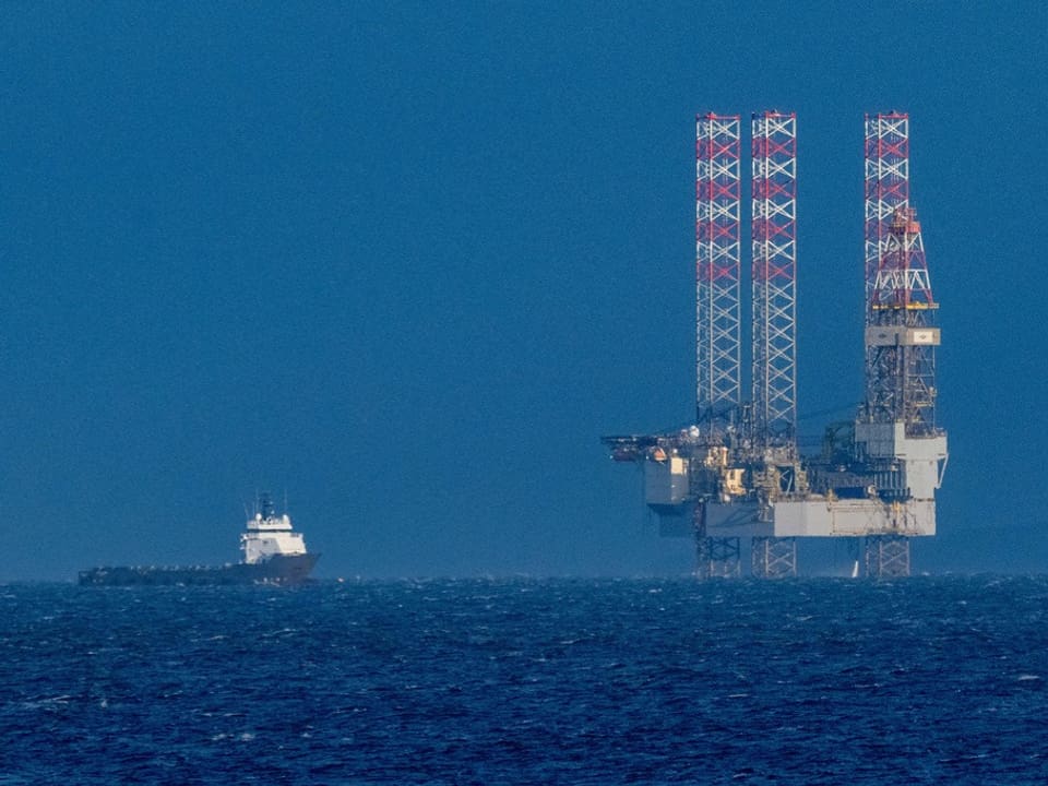 Schiff neben einer Ölplattform auf dem Meer.