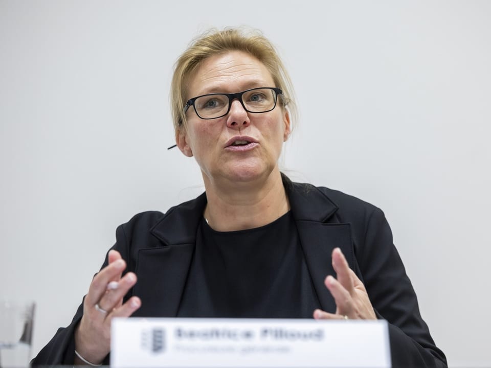 Frau mit Brille spricht in einem Meeting.