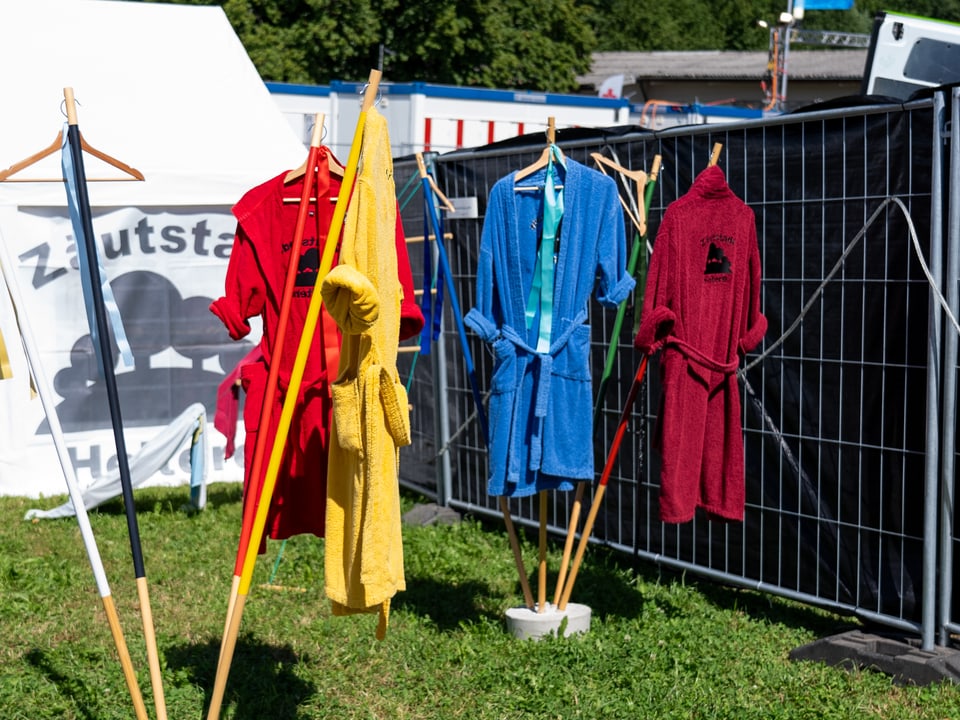 Vier Bademäntel hängen an einer Outdoor-Garderobe.