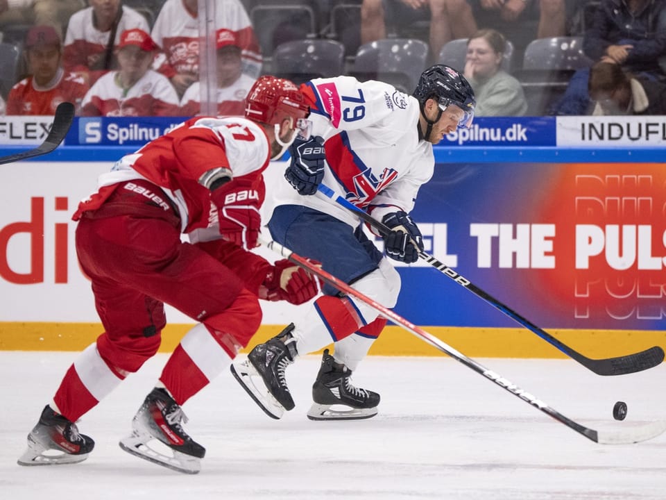 Eishockeyspiel zwischen Spielern in Rot und Weiss.