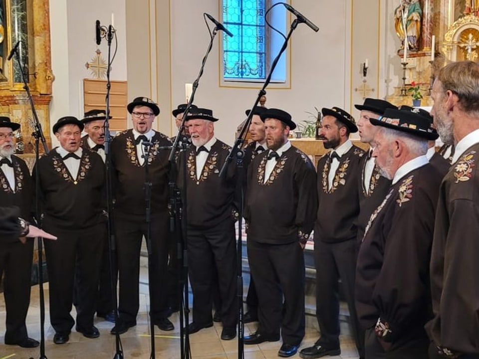 Jodler in Tracht singen in der Kirche.