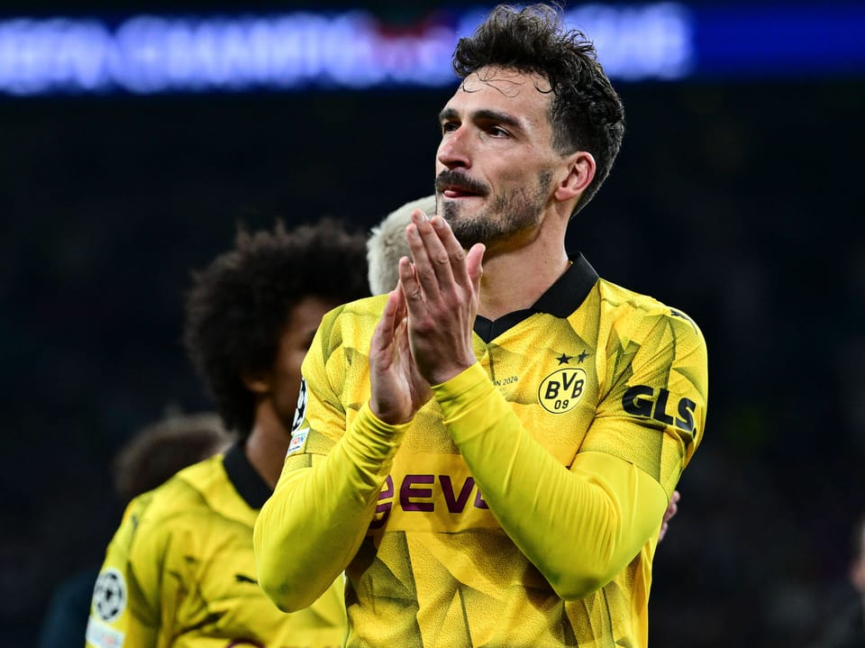 Fussballspieler im gelben Trikot von Borussia Dortmund klatscht.