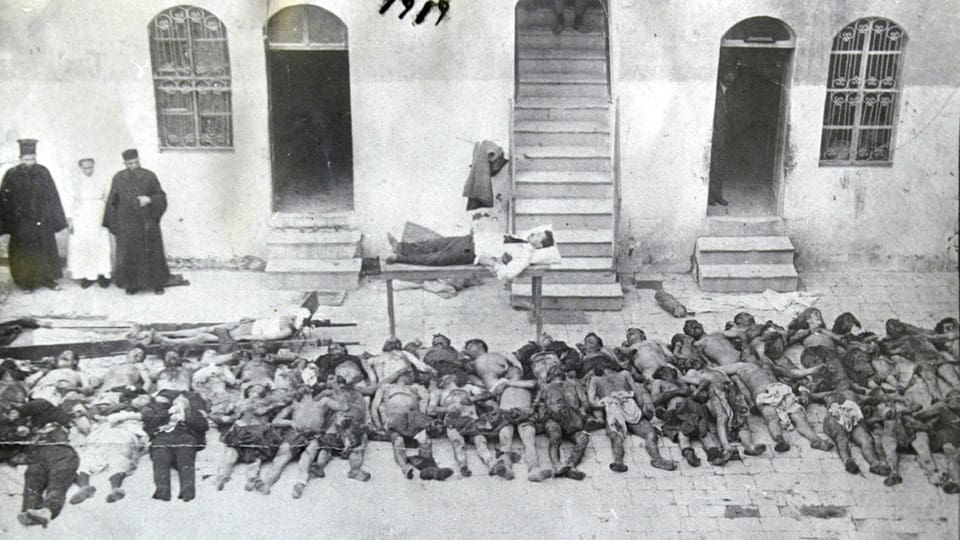 Ein Türke macht auf einer Pritsche einen Mittagsschlaf. Unter ihm tote Armenier.