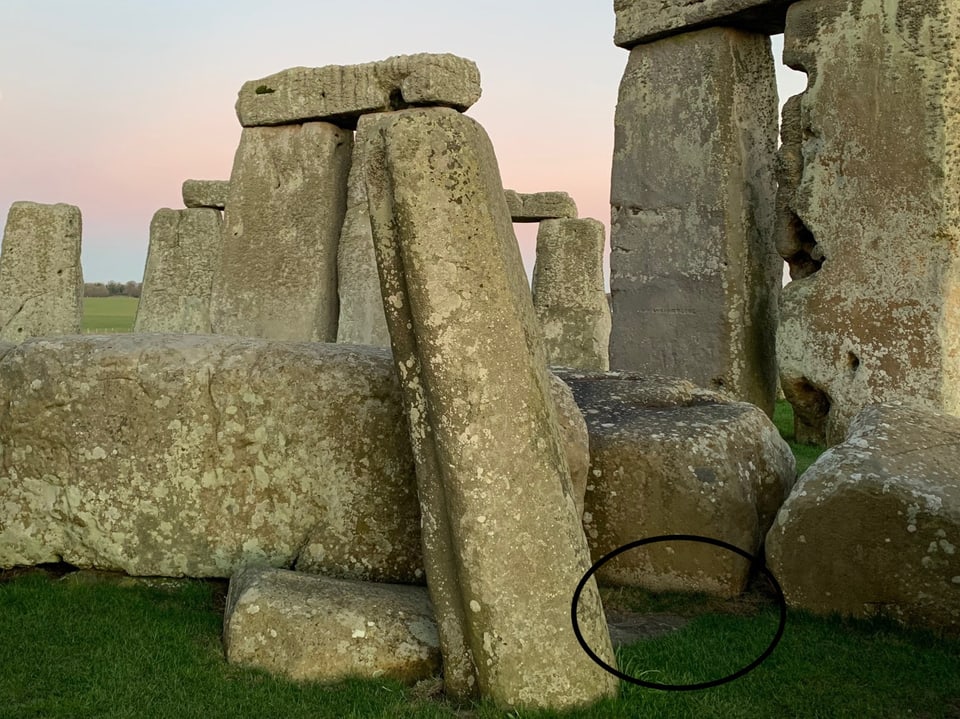 Detailaufnahme von Steinen des Stonehenge mit grünem Gras im Vordergrund.