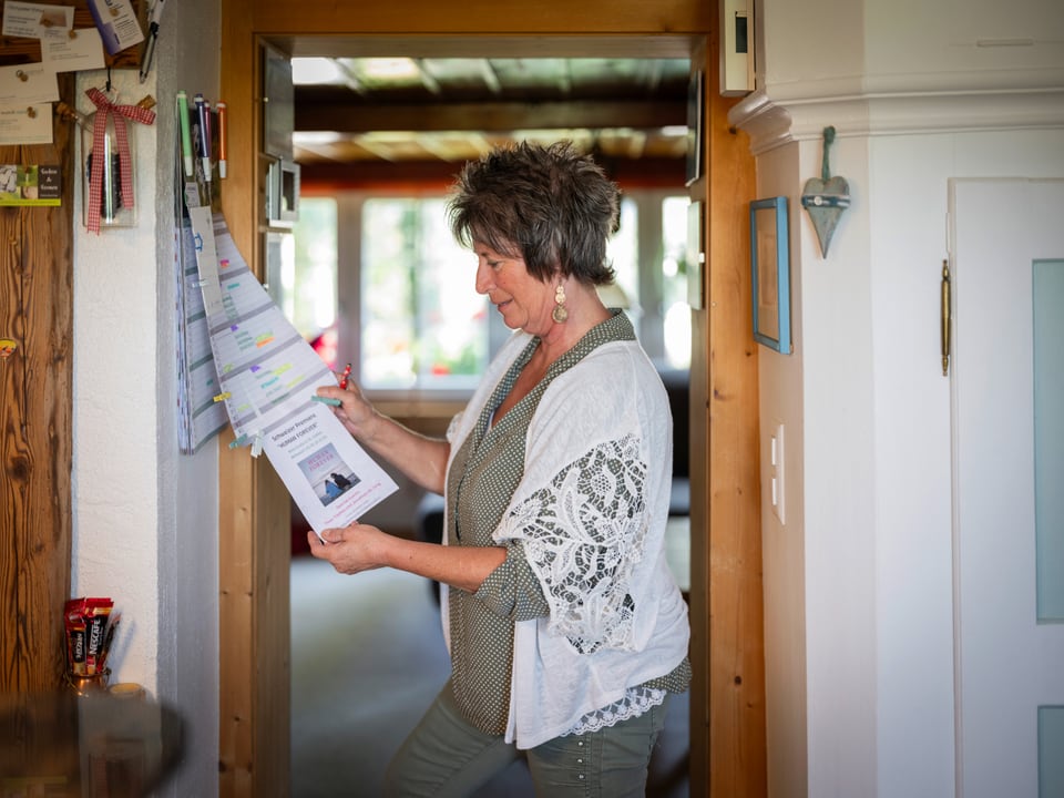 Frau schaut auf Kalender in einem Raum.