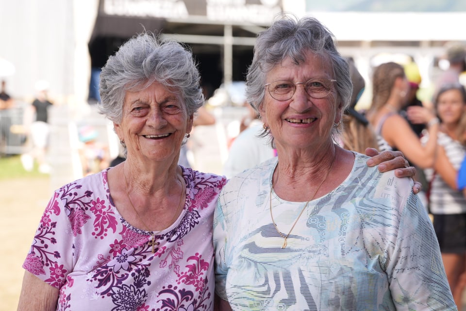 Zwei ältere Frauen lächeln bei einer Veranstaltung am Open Air Lumnezia 2024.