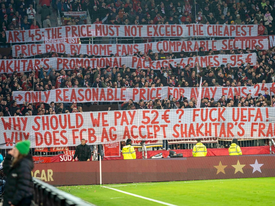 Fussballfans im Stadion halten Protestbanner hoch.