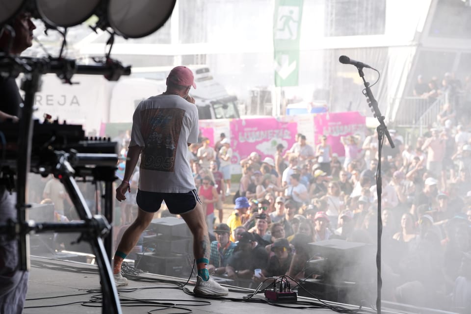 Mann auf der Bühne bei einem Musikfestival, Publikum im Hintergrund am Open Air Lumnezia 2024.