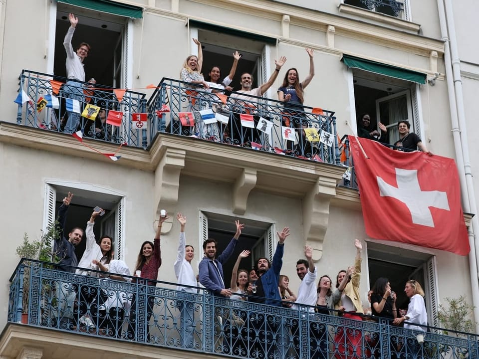 Fans bei der Eröffnungsfeier jubeln auf Balkonen.