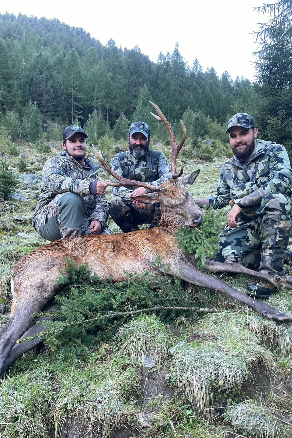 Ein paar gesellige Herren mit einem gewaltigen Hirsch.