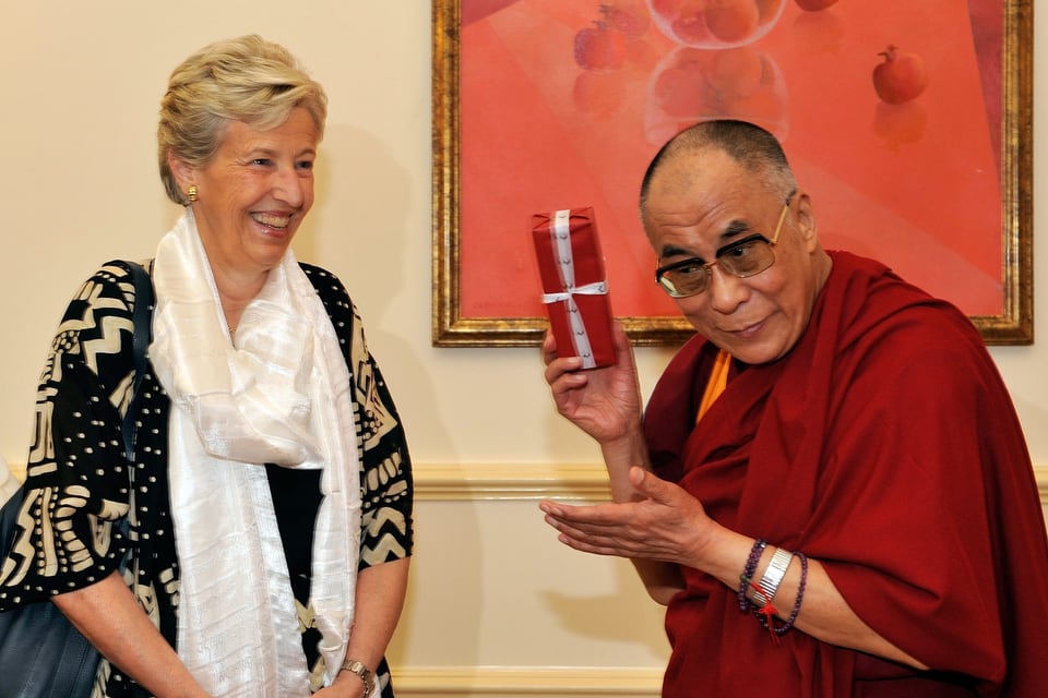 Dalai Lama hält ein Geschenk in den Händen