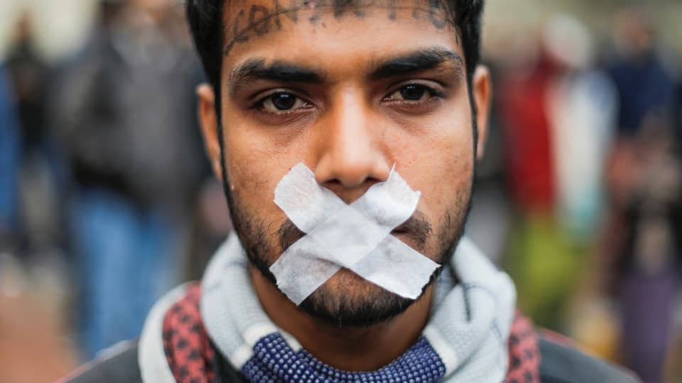 Demonstrant in Indien mit zugeklebtem Mund