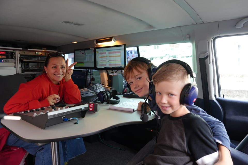 Person mit zwei Kindern in einem Radiostudio-Setup.