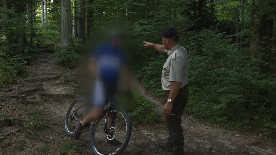 Polizist und Velofahrer im Wald