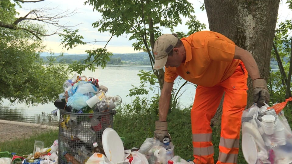 Mann in orangen Übergewand sammelt Abfall 