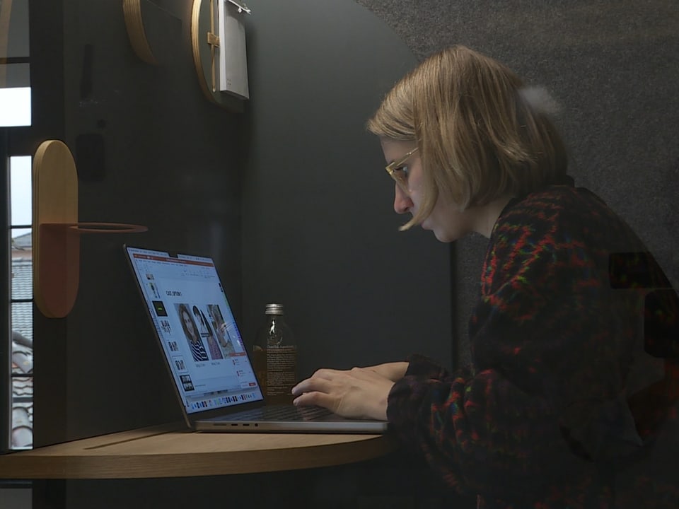 Stephanie, eine junge Frau mit kurzen, blonden Haaren sitzt und arbeitet an ihrem Laptop.