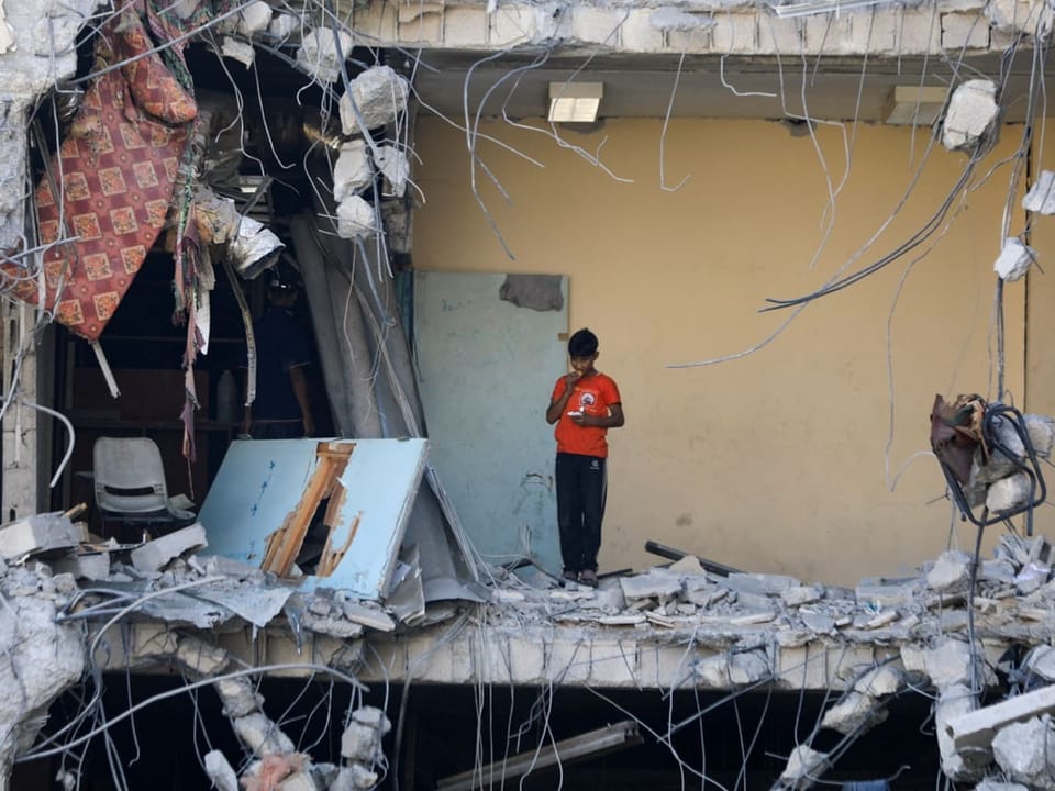 Kind in einem vom Krieg zerstörten Gebäude.