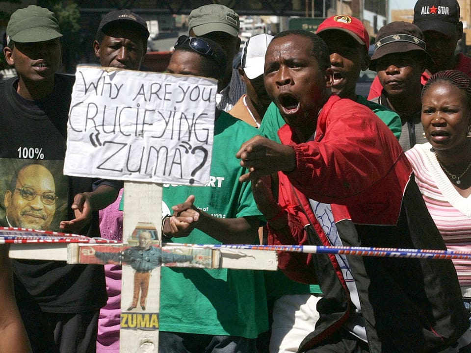 Ein Anhänger des Präsidenten mit Schild: «Weshalb kreuzigt ihr Zuma?»