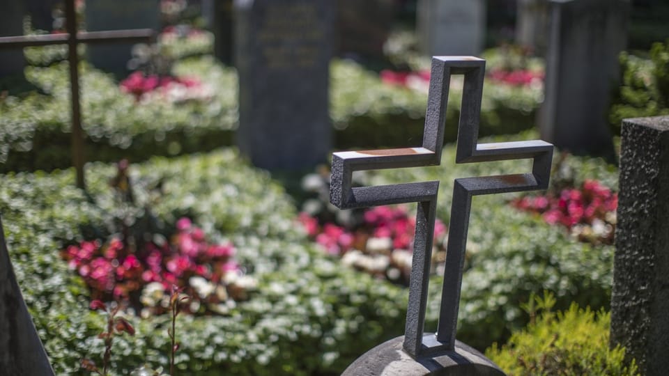 Kreuz auf einem Grabstein auf einem Friedhof