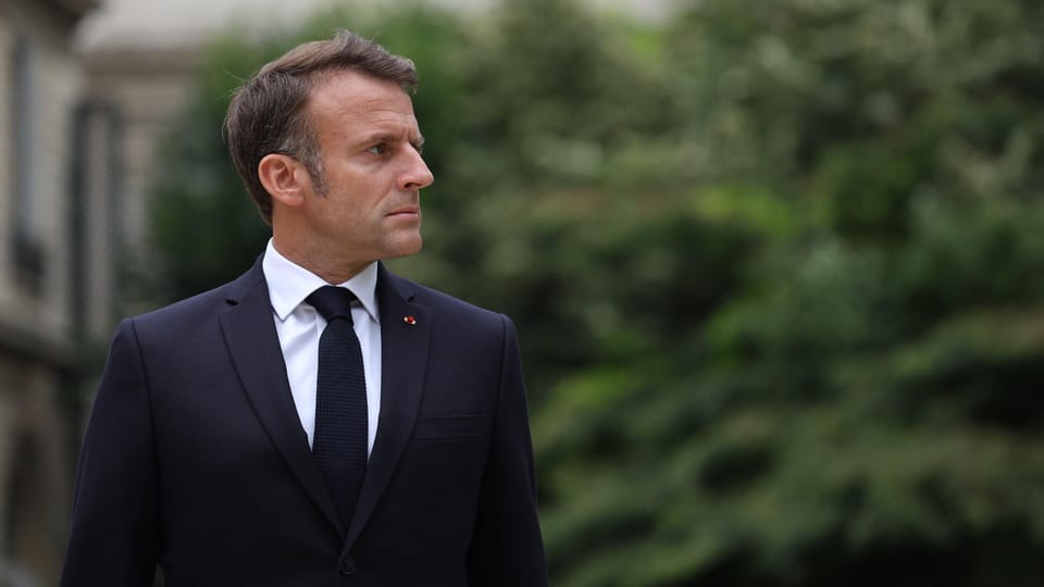 Emmanuel Macron im Anzug, der nach links schaut, im Freien.