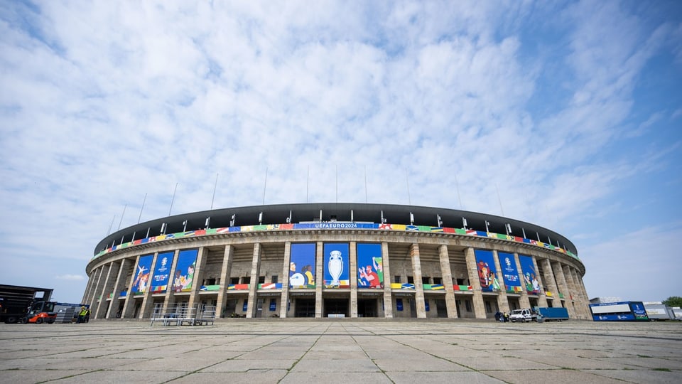 Aussenansicht eines stadions mit Flaggen und Bannern.