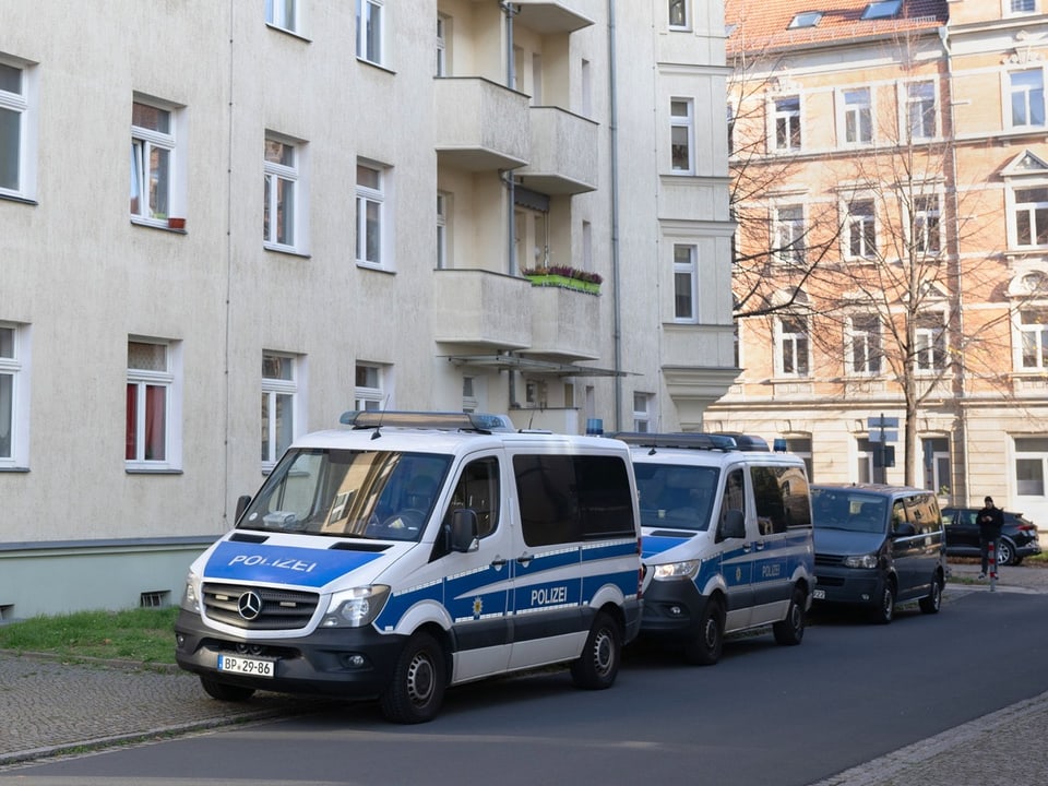 Polizeiwagen parken auf einer Wohnstrasse.