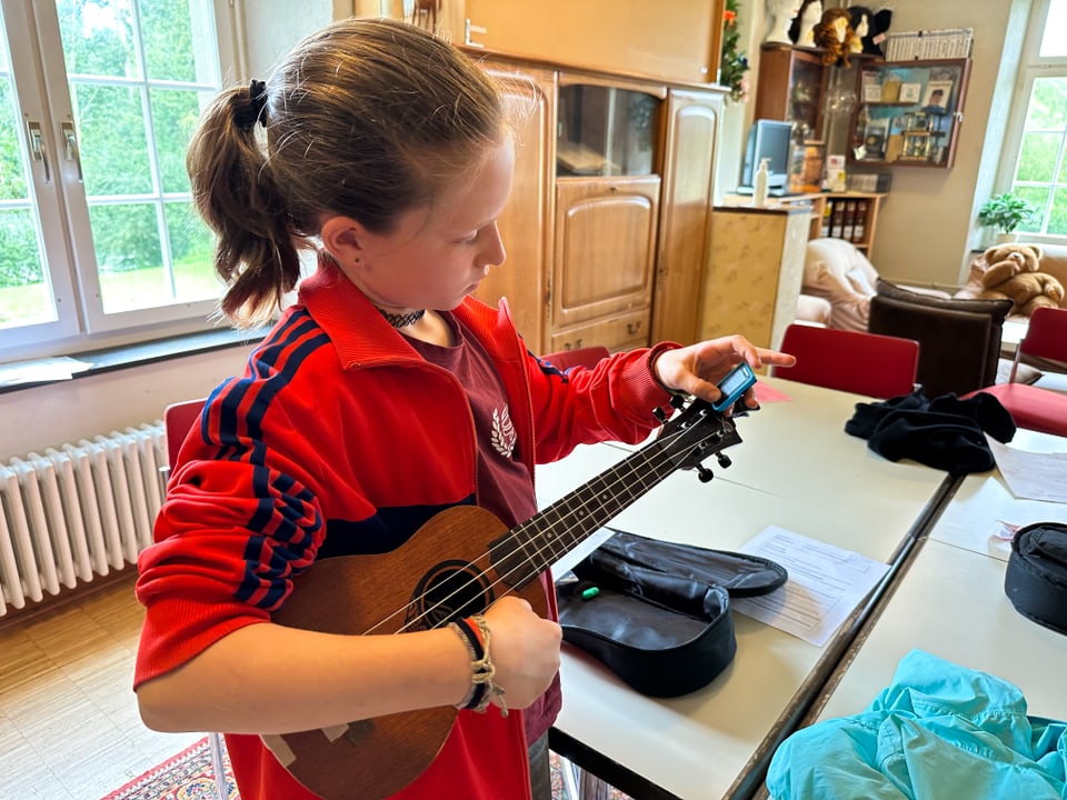 Ein Mädchen stimmt ihre Ukulele