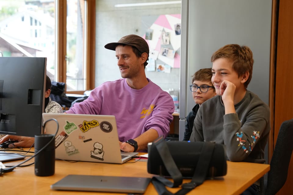 Mann und Jungen arbeiten an einem Computer.