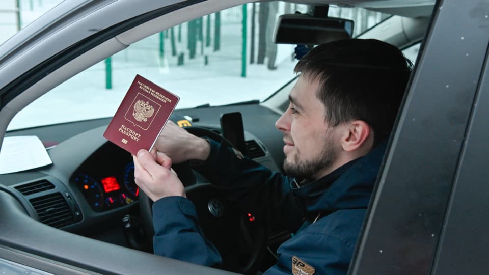 Ein Mann zeigt an der finnisch-russischen Grenze seinen Pass.