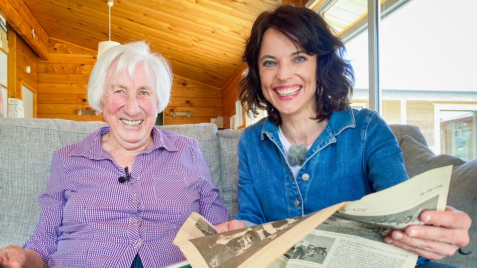 Hanni und Mona sitzen auf dem Sofa. Auf dem Schoss ein Fotoalbum und lachen in die Kamera.