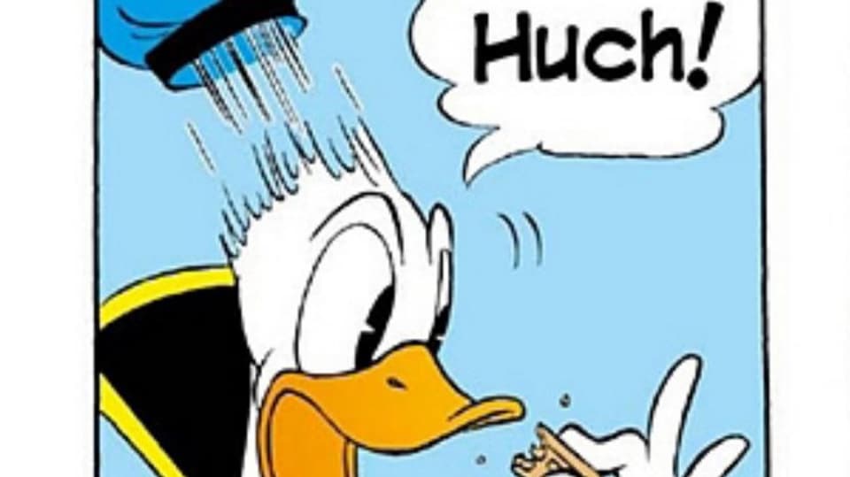 Donald Ducks Gesicht und eine Hand. Dazu in der Sprechblase der Text «Huch!»