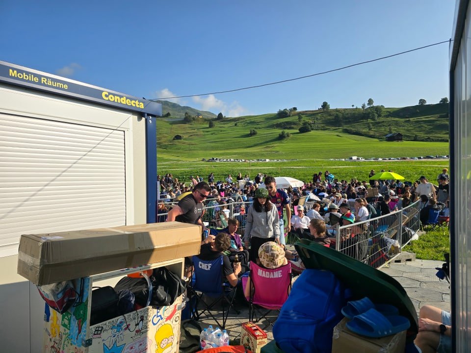 Menschenmenge bei einem Outdoor-Event auf einer Wiese.