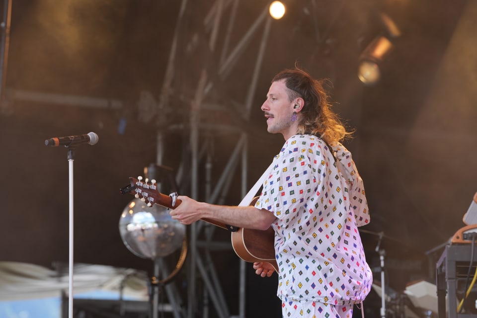 Musiker auf der Bühne mit Gitarre bei einem Konzert.