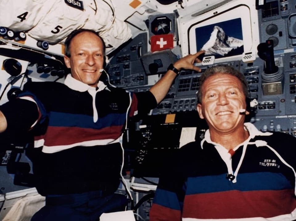 Zwei Astronauten in der Raumfähre mit Bild des Matterhorns.