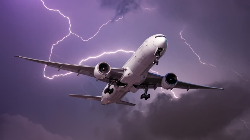 Flugzeug fliegt während eines Gewitters mit Blitzen.