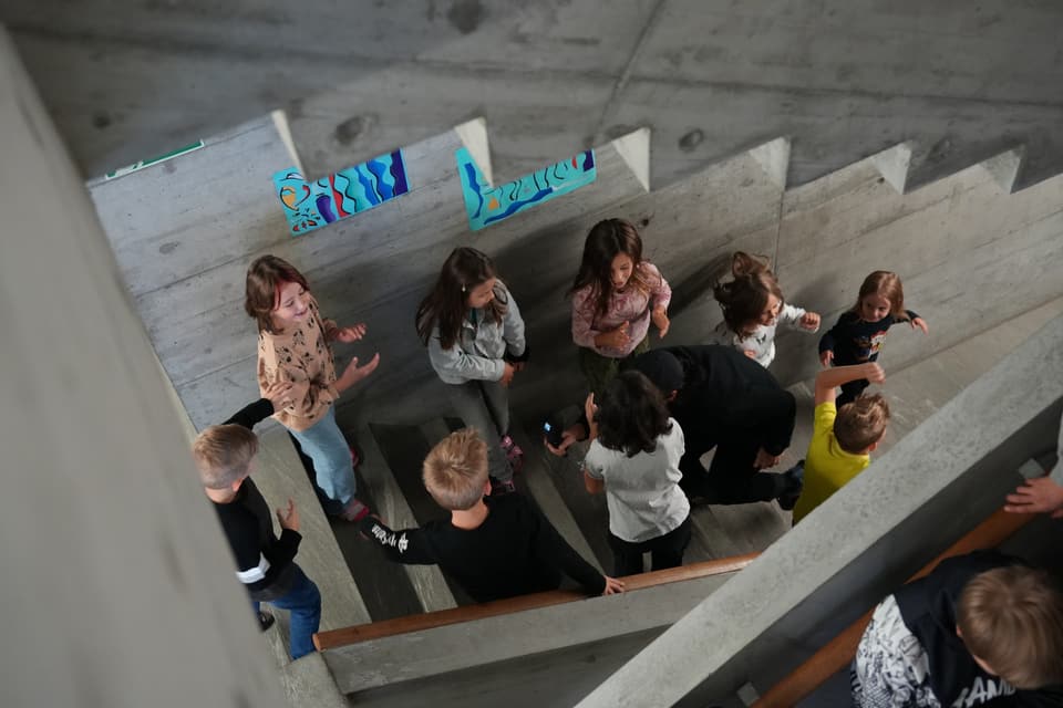 Kinder spielen auf einer Betontreppe.