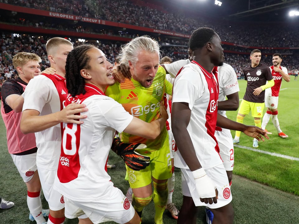 Ajax-Spieler feiern auf dem Spielfeld im Stadion.