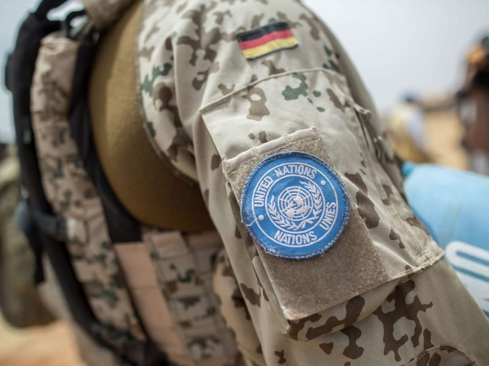 Nahaufnahme einer Uniform eines Bundeswehrsoldaten in Mali. An der Schulter ist ein UNO-Emblem und eine deutsche Flagge.
