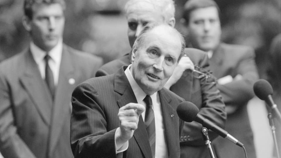 Mitterrand hält am Mikrofon eine Rede.
