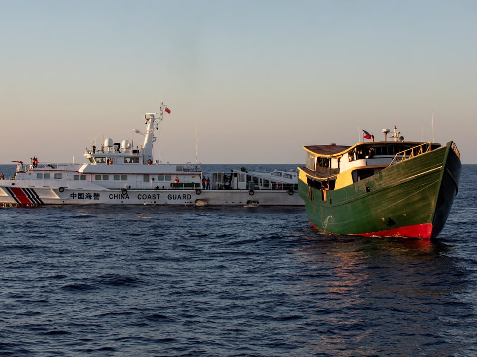 Chinesisches Küstenschutzschiff und ein Fischerboot im Meer.