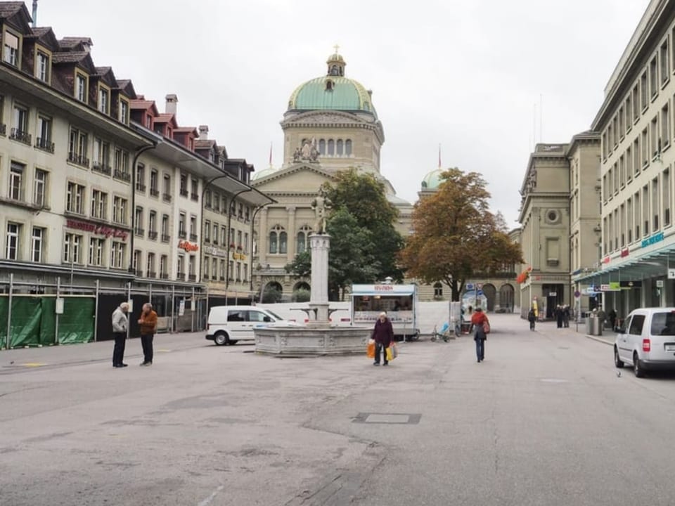 Strasse mit Gebäuden und Personen in einer Stadt.