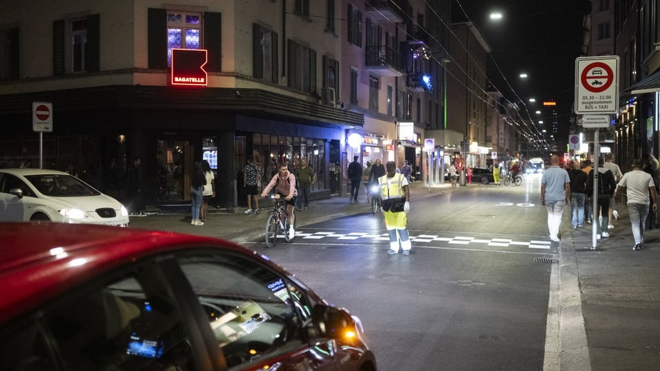 Langstrasse zur Abendzeit: Ein Mann weist die Autos auf das neue Fahrverbot hin