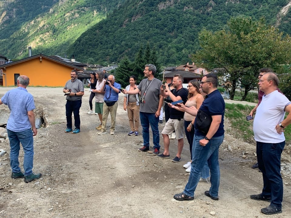 Medienschaffende und Behörden stehen im Dorf Lostallo
