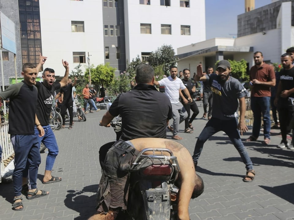 Ein Palästinenser stellt einen von Hamas-Kämpfern getöteten Israeli in einem Kibbuz nahe dem Gazastreifen zur Schau.