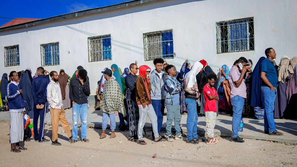 Gruppe von Menschen in einer Schlange vor einem Gebäude in Somalia.