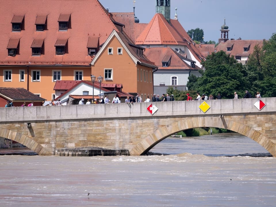 Brücke über einen Fluss mit historischer Architektur im Hintergrund.