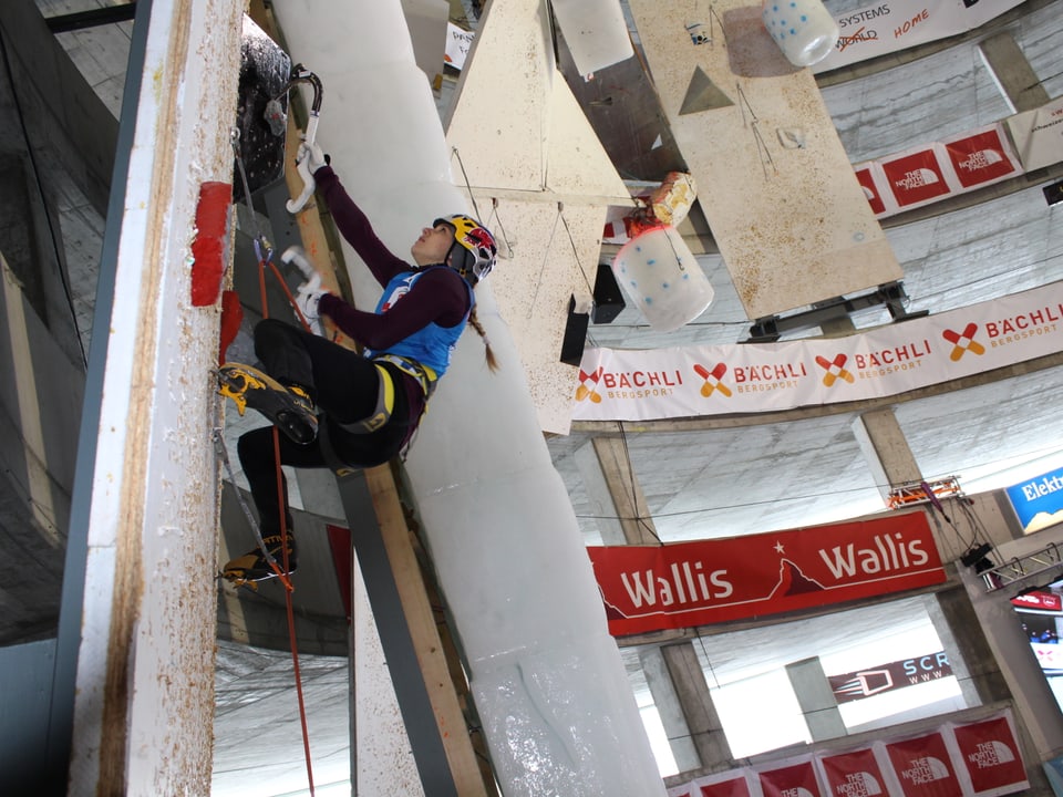 Eine Sportlerin an der künstlichen Kletterwand.